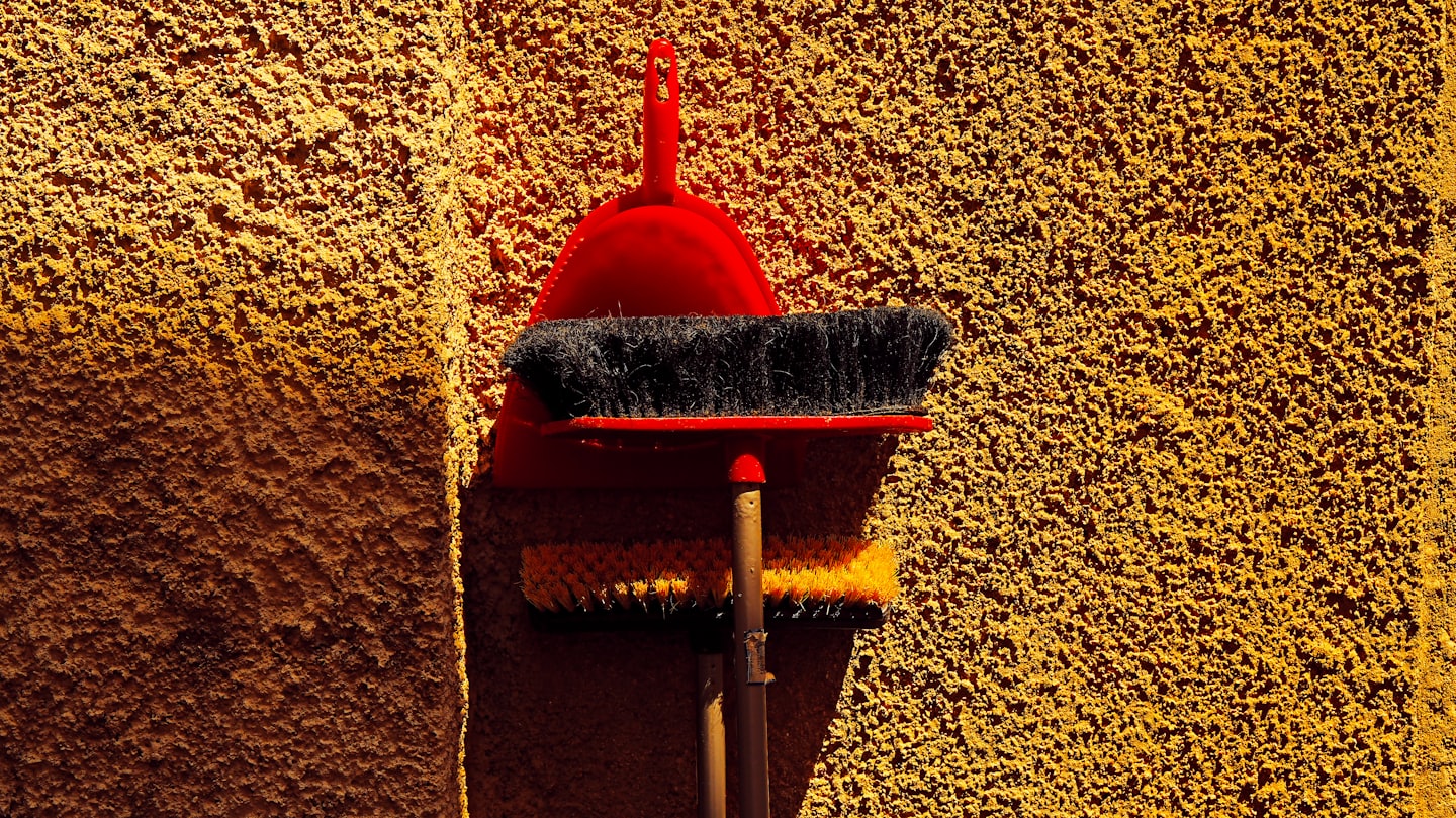 Picture showing a brush and dustpan on sand